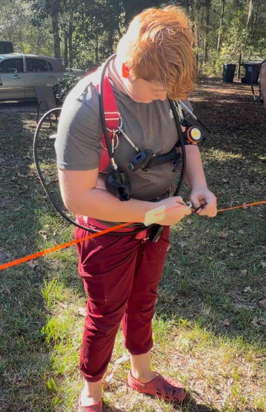 Malachi Jack practicing dry-land guideline handling in a technical diving harness
